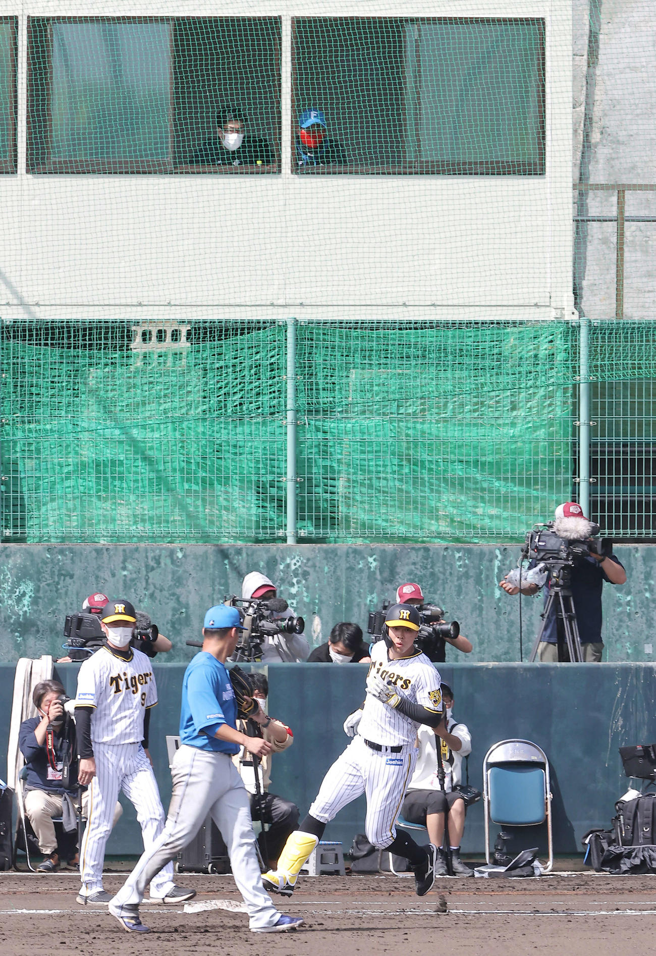 阪神対日本ハム　1回裏阪神2死三塁、佐藤輝（下右）は左前適時打を放ち一塁に向かう。上段右は日本ハム新庄監督（撮影・上山淳一）