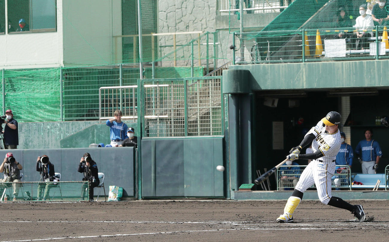 阪神対日本ハム　1回裏阪神2死三塁、左前適時打を放つ佐藤輝。左上の窓から見つめるのは日本ハム新庄監督（撮影・前田充）