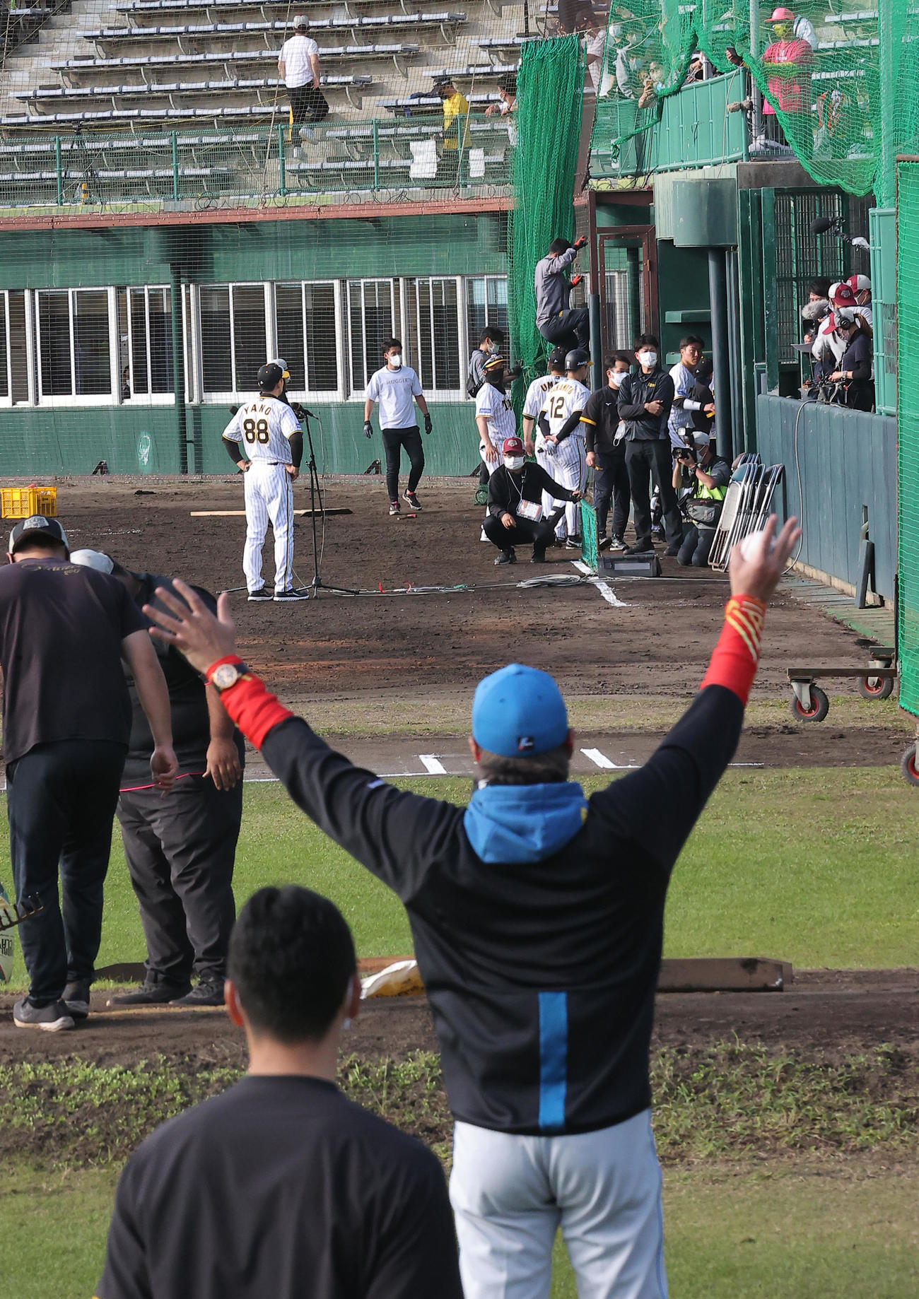 練習試合・阪神対日本ハム　日本ハム新庄監督（手前右）は試合後のインタビューをする矢野監督に向かって手を振るも気づかず...（撮影・上山淳一）