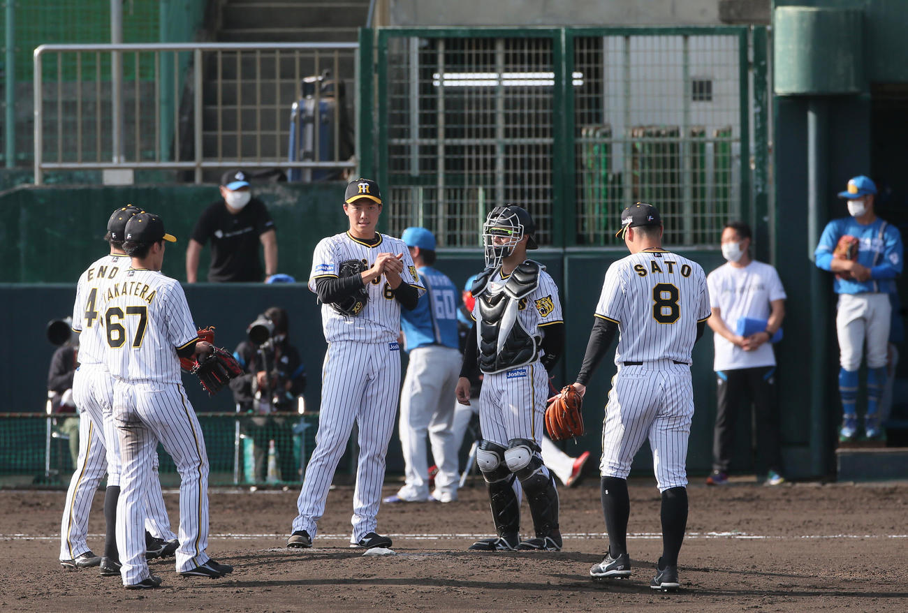 阪神対日本ハム　9回表日本ハム2死二塁、石井に中越え適時二塁打を浴びた湯浅（左から3人目）とマウンドに集まる阪神内野陣（撮影・上山淳一）