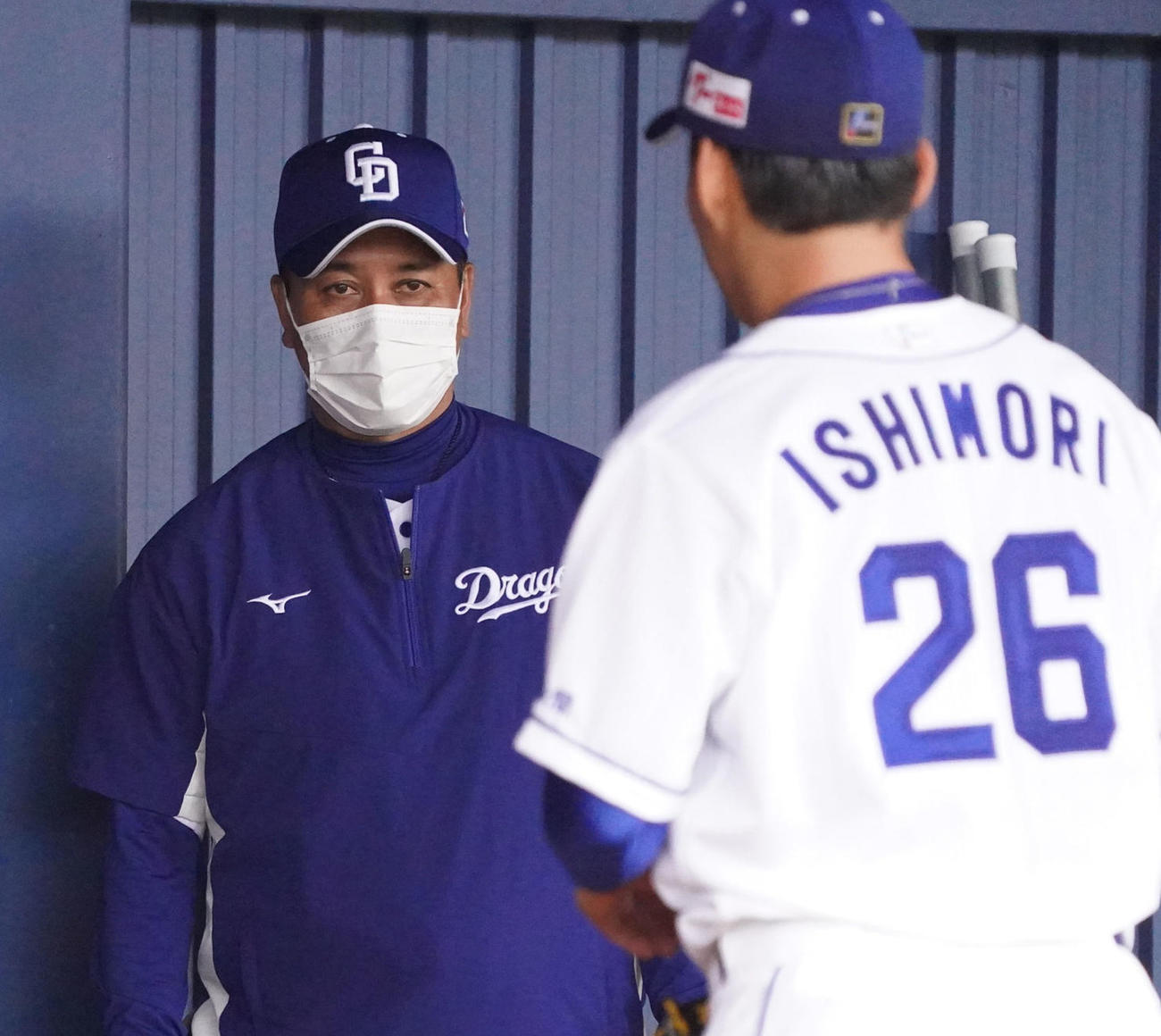 2022年2月2日、ブルペンで投球練習をする石森（右）に話をする落合ヘッド兼投手コーチ