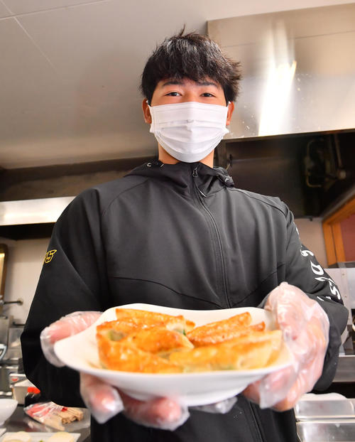 焼き上がった餃子を披露する椋木（撮影・和賀正仁）