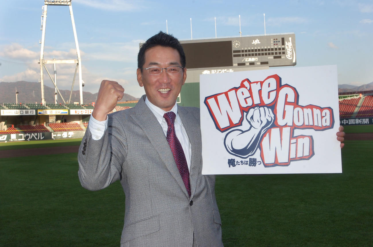 2010年度の広島キャッチフレーズを片手にポーズを決める野村謙二郎監督（撮影・倉掛優一）＝2009年12月2日、マツダスタジアム（MAZDA Zoom－Zoom　スタジアム広島、新広島市民球場）