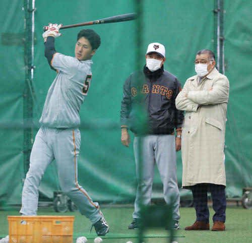 トス打撃する巨人秋広（左）を見る原監督（後方左）と掛布氏（撮影・河田真司）
