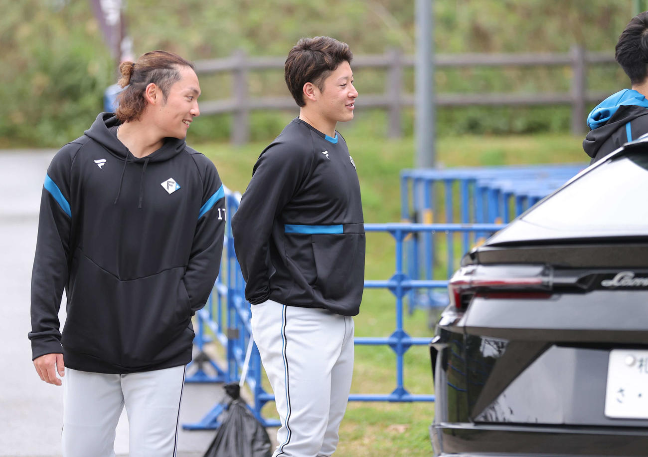 日本ハム新庄監督が乗ってきたランボルギーニ・ウルスを興味深そうに見つめる、左から伊藤、吉田（撮影・河野匠）