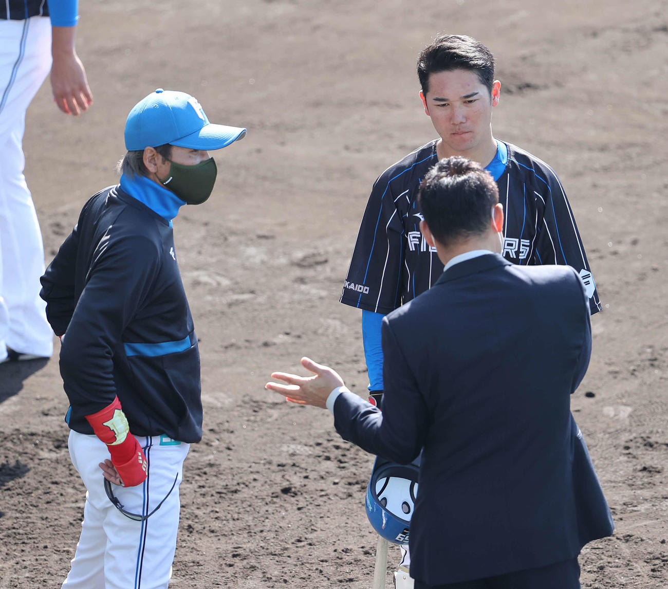 練習試合　日本ハム対阪神　試合前、前田氏（右手前）から打撃指導を受ける日本ハム宮田（右後方）。左は新庄監督（撮影・河野匠）