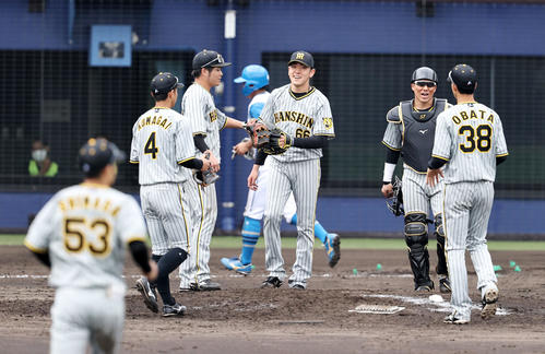 日本ハム対阪神　日本ハムと引き分けマウンドでタッチする小川（中央）らナインたち（撮影・加藤哉）