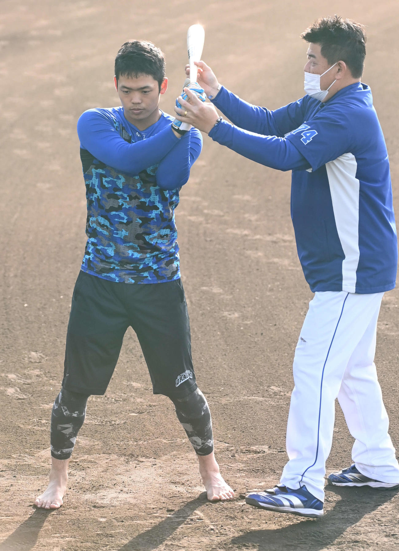 はだしでティー打撃を行う中日根尾（左）は中村紀コーチから指導を受ける（撮影・前岡正明）