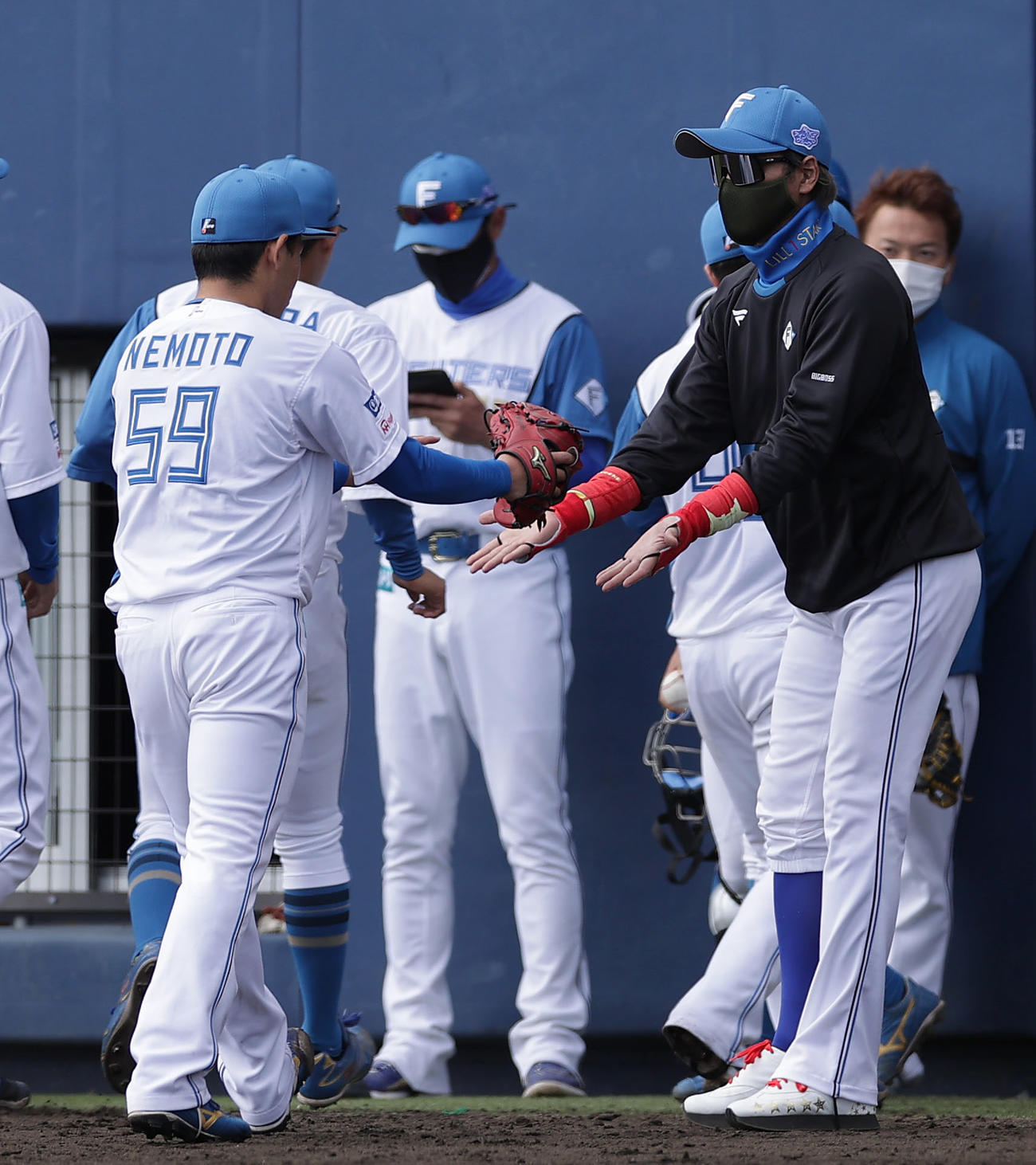 日本ハム対阪神　6回表の阪神打線を3者凡退に抑えた日本ハム根本（手前左）を迎える新庄監督（同右（撮影・前田充）