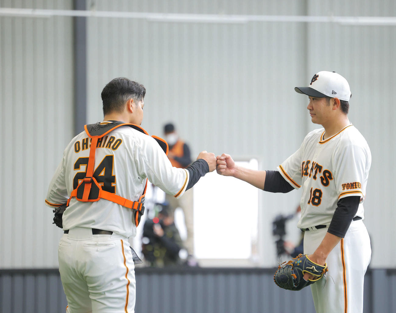 ブルペン投球を終え、グータッチを交わす巨人大城（左）と菅野（撮影・河田真司）