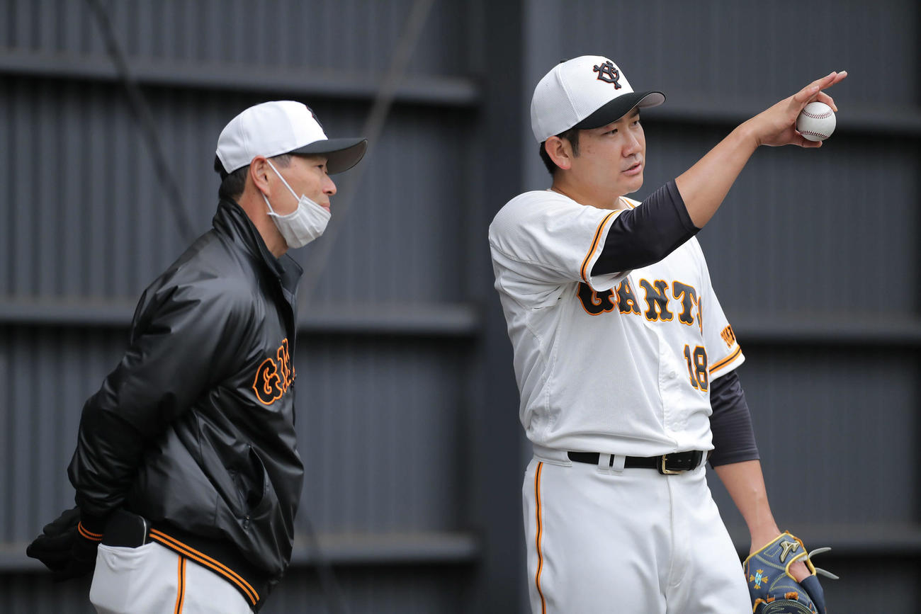 ブルペンで桑田投手チーフコーチ（左）と言葉を交わす巨人菅野（撮影・河田真司）