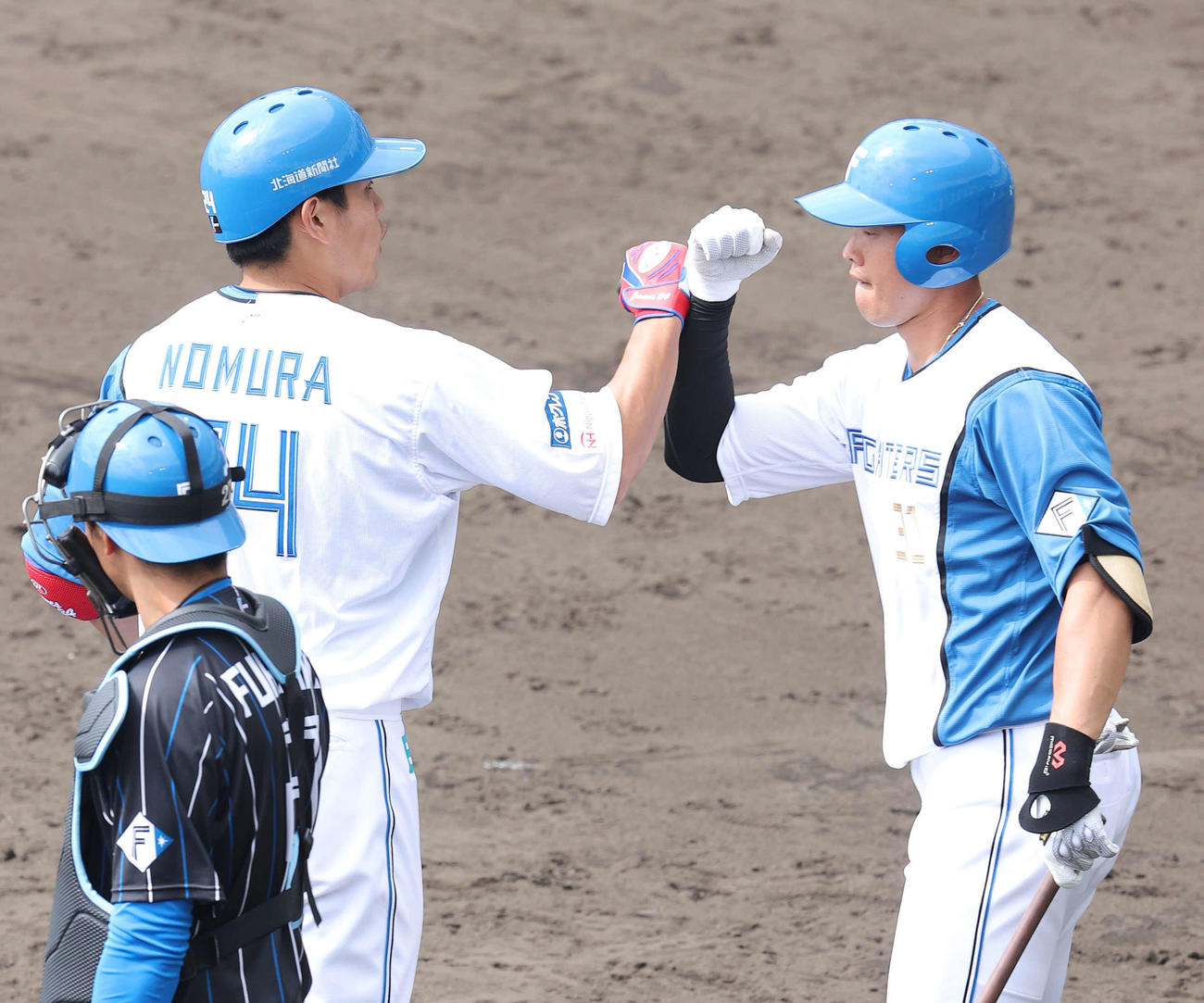 紅白戦で1死満塁の状況から満塁弾を放ち生還した野村（左）。右は高浜（撮影・河野匠）