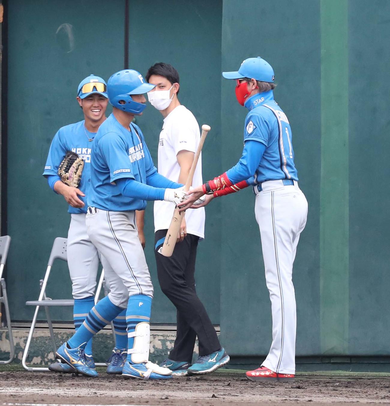 楽天対日本ハム　4回表、2点本塁打を放った石井（左）を出迎える新庄監督（撮影・黒川智章）