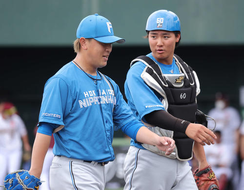 練習試合　楽天対日本ハム　1回裏を終え言葉を交わしながら引き揚げる河野（左）と郡（撮影・河野匠）