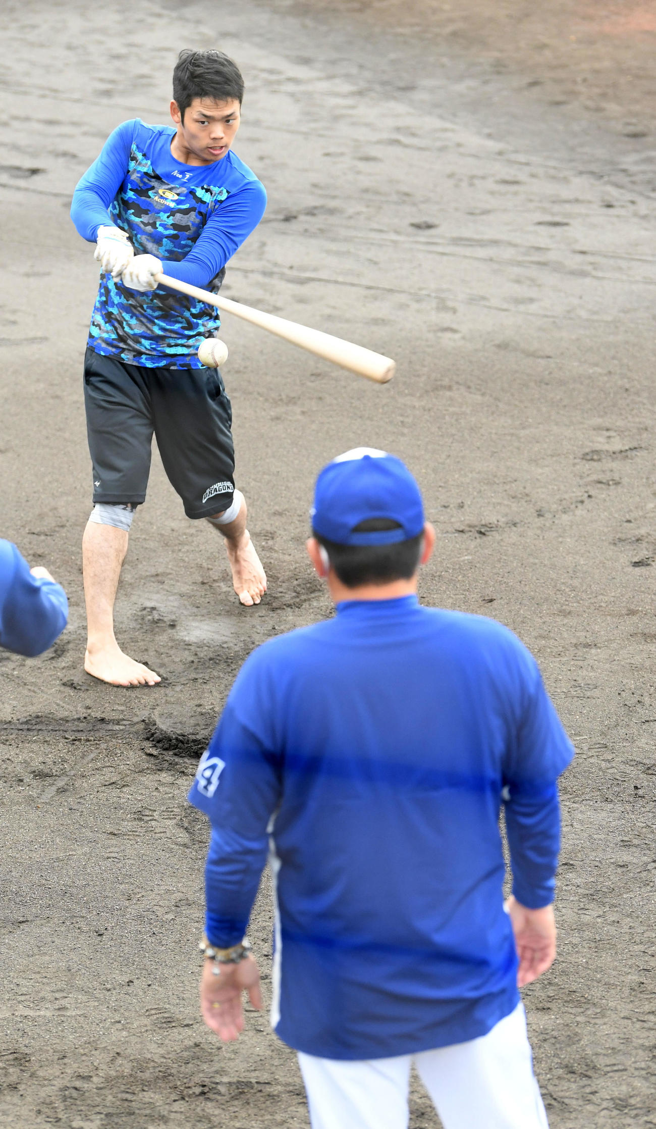連日、中村紀洋コーチ（背中）と早出で裸足ティーを行う根尾昂（撮影・前岡正明）