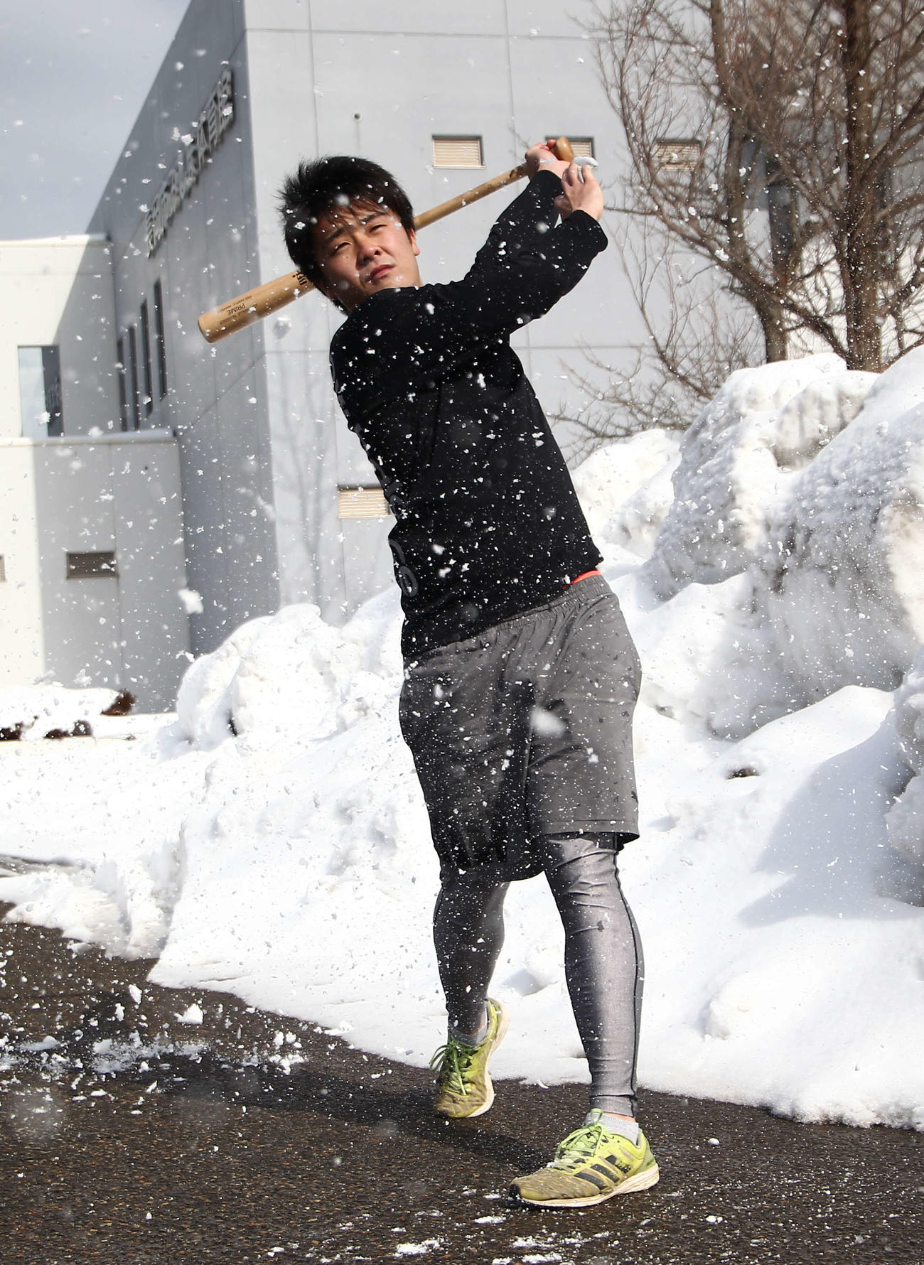 雪の球をバットで粉砕する熊倉