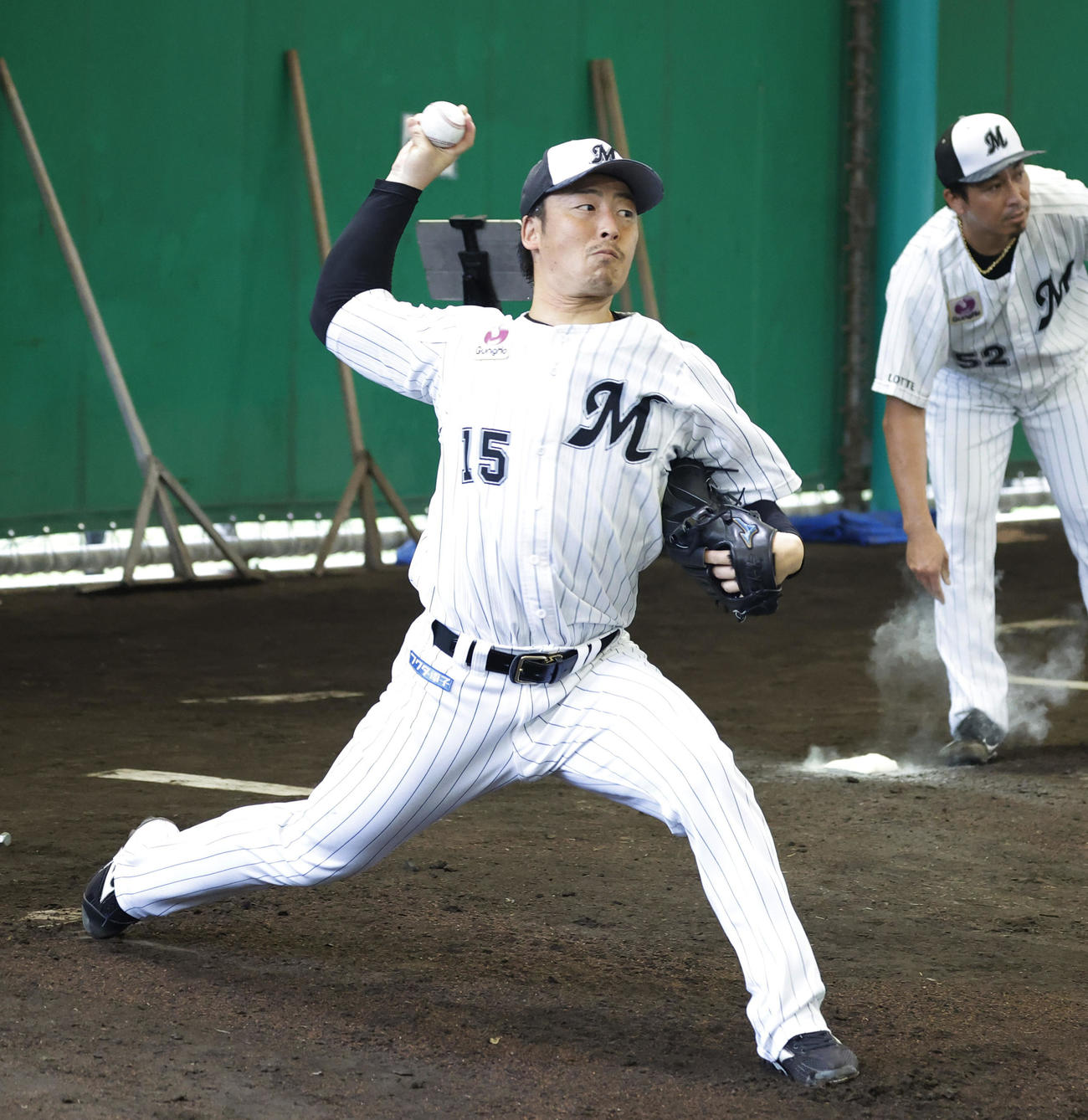 ブルペンで投球練習する美馬
