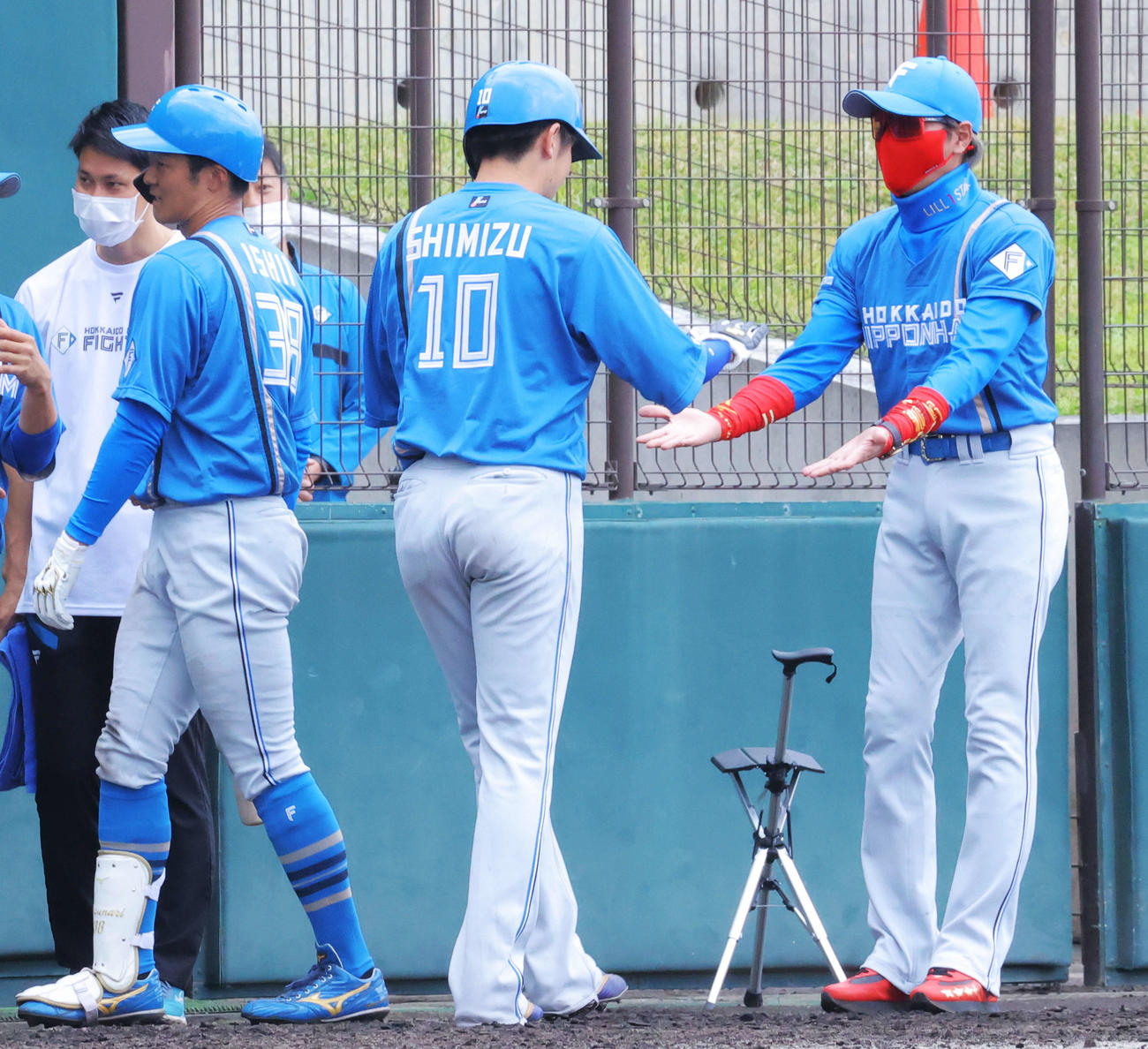 楽天対日本ハム　4回表日本ハム1死一塁、逆転2点本塁打で生還する石井（左）と清水を迎える新庄監督（撮影・河田真司）