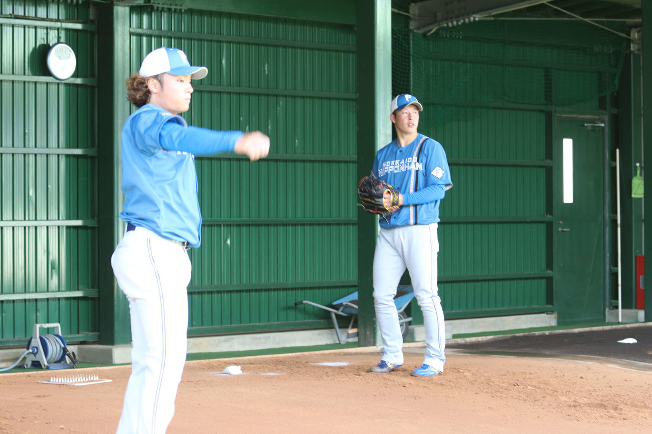 ブルペンで投球する吉田（右）と伊藤（撮影・小林憲治）