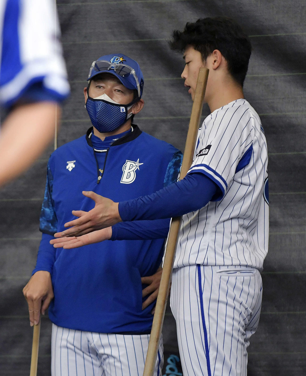 投球練習後、小園（右）と話すDeNA三浦監督