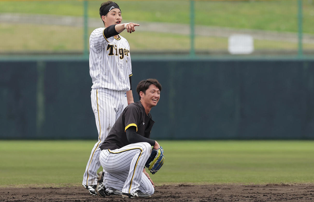 阪神井上一樹ヘッドコーチによる「愛の無事着」デスノックに臨む近本（手前）と木浪（撮影・前田充）