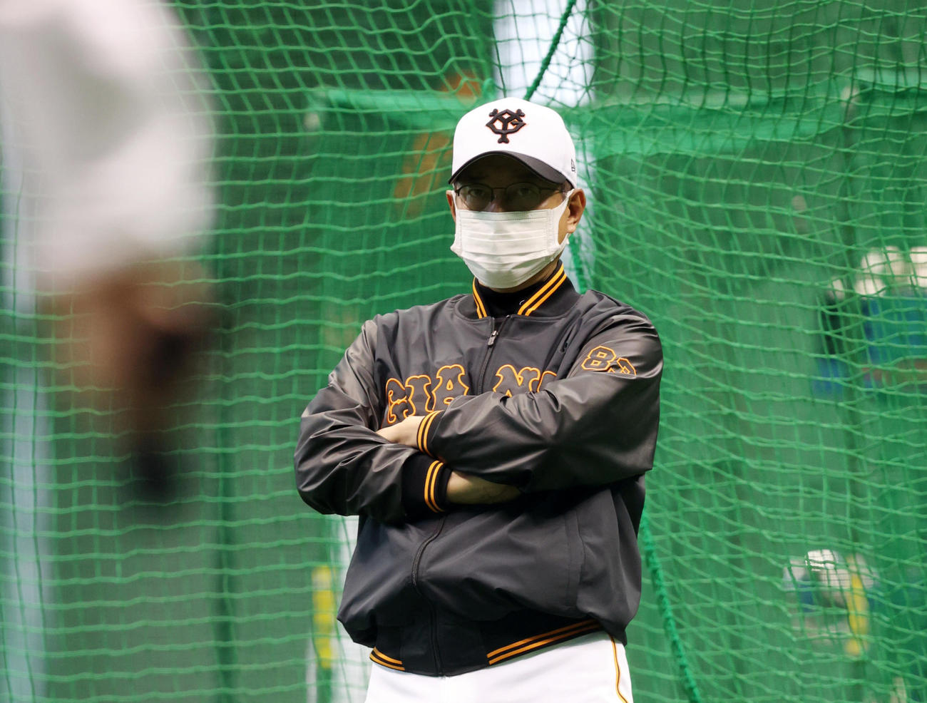 沖縄キャンプ初日、あいにくの雨スタートなり、室内練習場で野手陣のアップを見つめる原監督（撮影・狩俣裕三）