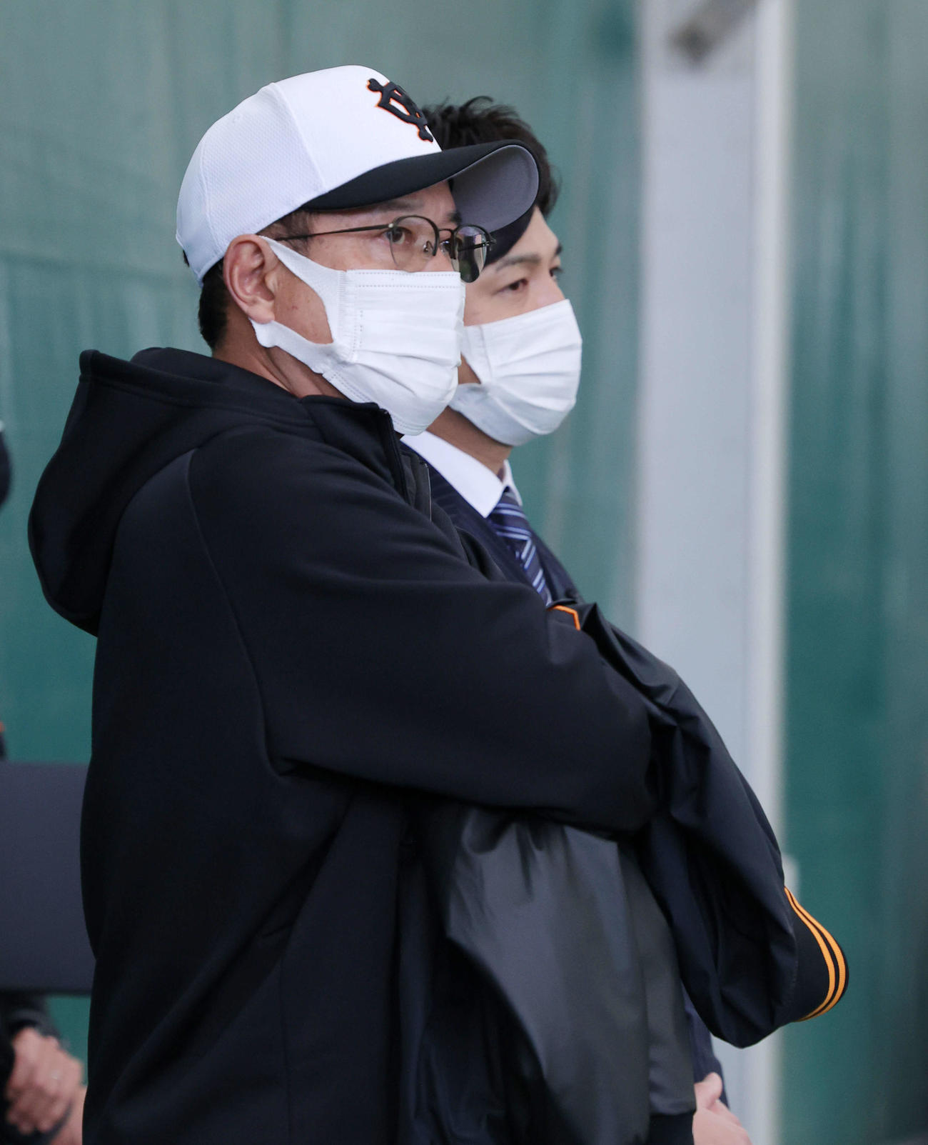 ブルペン投球する選手を見る原監督（手前）と高橋氏（撮影・河田真司）