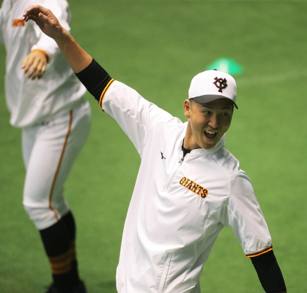 ウオーミングアップで笑顔を見せる巨人秋広（撮影・河田真司）