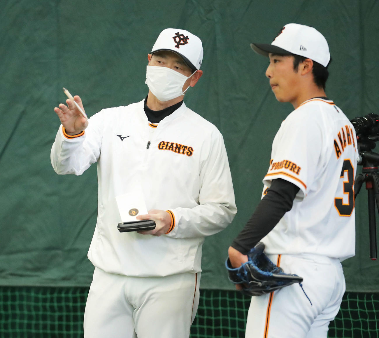 ブルペンで巨人赤星（右）と言葉を交わす桑田投手チーフコーチ（撮影・河田真司）