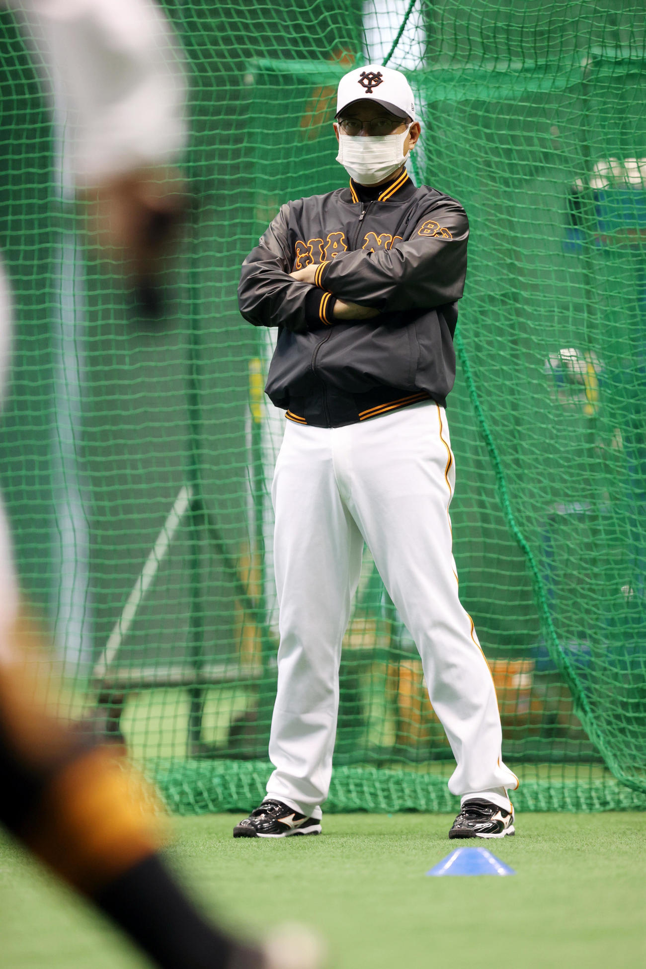沖縄キャンプ初日、あいにくの雨スタートなり、室内練習場で野手陣のアップを見つめる原監督（撮影・狩俣裕三）