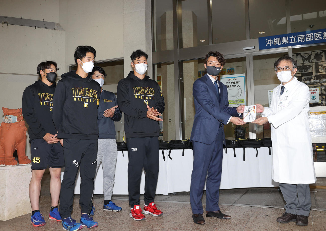 こども医療センターを訪問し、和氣院長（右）に目録を手渡す、左から遠藤、小幡、高寺、佐藤輝、阪神OBの鳥谷氏（代表撮影）