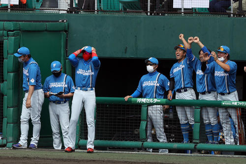 巨人対日本ハム　3回表日本ハム1死一、二塁、石井が2点適時二塁打を放ち、チームメートが喜ぶ中、なぜか頭を抱える新庄監督（撮影・狩俣裕三）