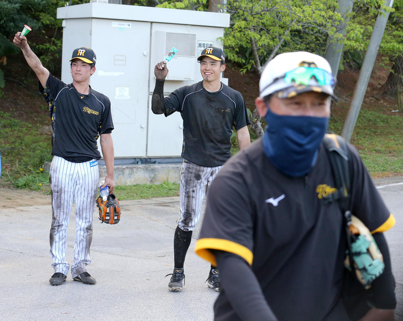 デスノックを終え、久慈内野守備兼バント担当コーチ（手前）からご褒美アイスをもらい喜ぶ高寺（左）と遠藤（撮影・上山淳一）