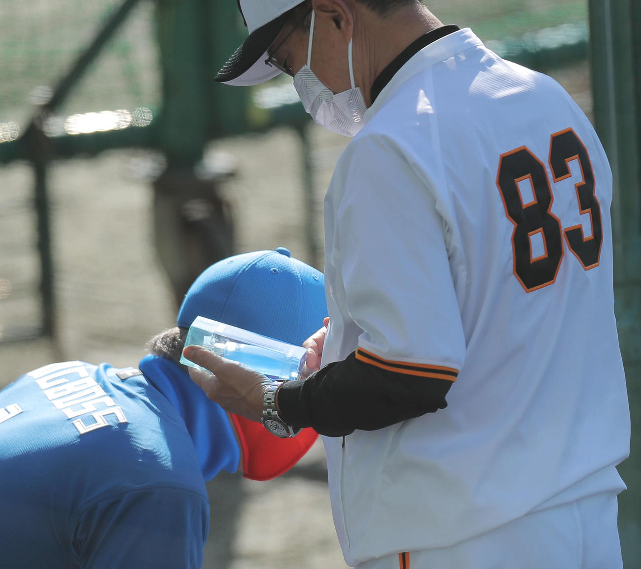 日本ハム新庄監督（左）に香水を渡される巨人原監督（撮影・河田真司）
