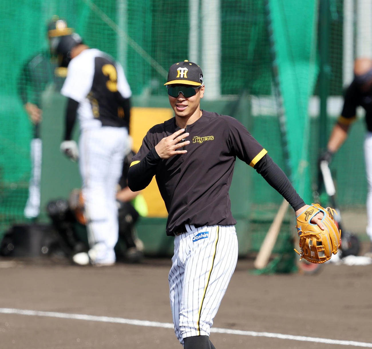 三塁守備練習中の佐藤輝は打球に当たりそうになり右手を胸に当てて安堵（あんど）する。左は大山（撮影・加藤哉）