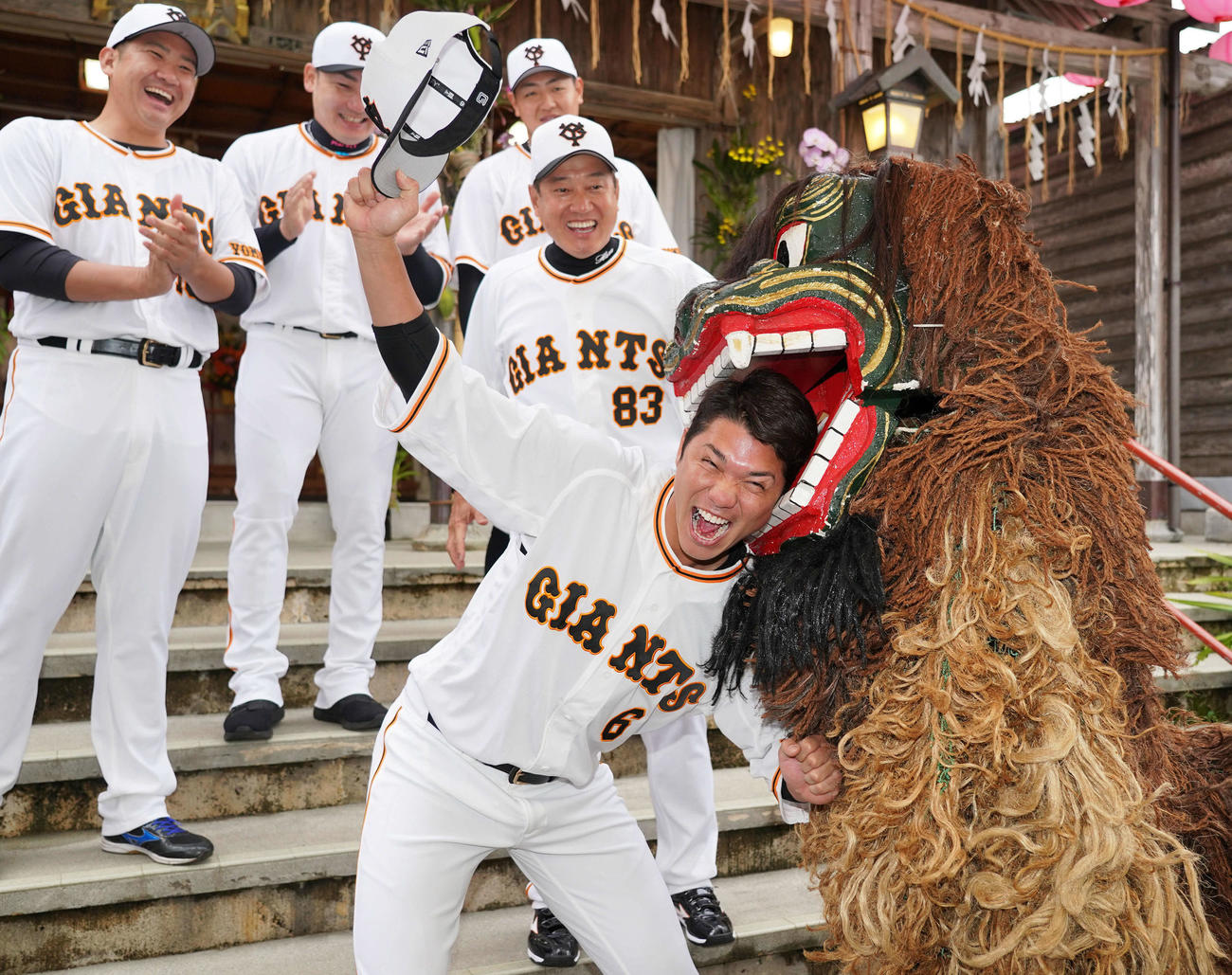 沖宮を参拝し、獅子舞に頭をかまれる巨人坂本（手前）。後方左から菅野、丸、岡本和、原監督