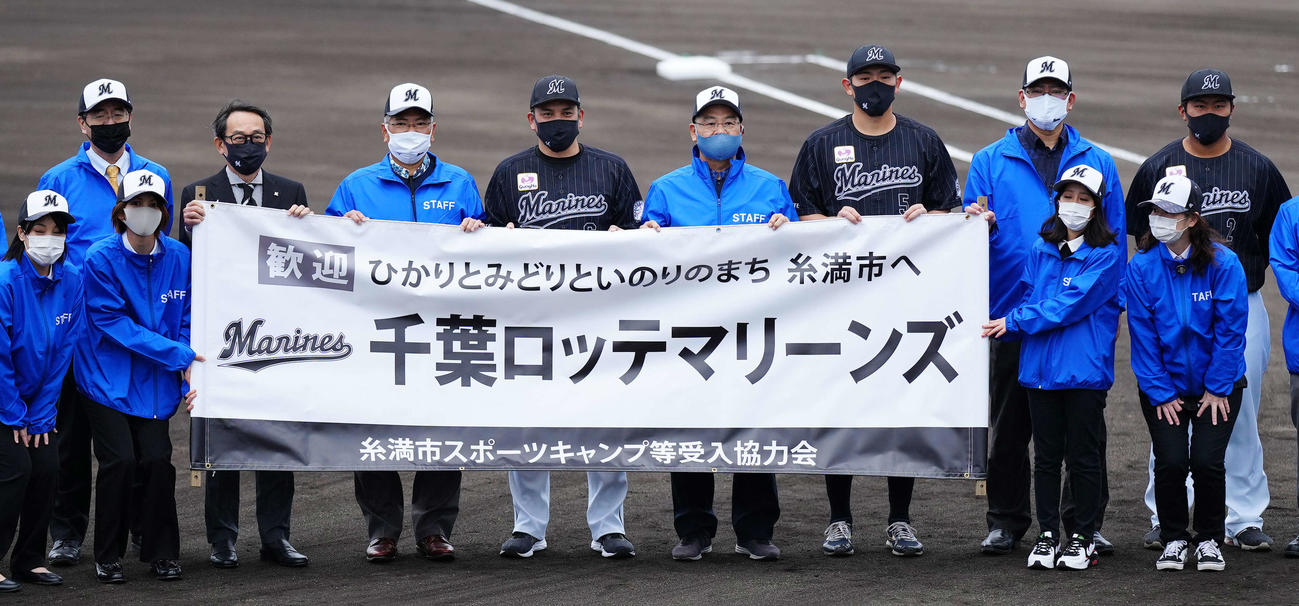 2次キャンプが行われる沖縄・糸満市西崎球場での歓迎セレモニーで写真に納まるロッテ井口監督（左から6人目）ら。同4人目は河合オーナー代行兼球団社長、同8人目は安田、右端は松川（撮影・江口和貴）