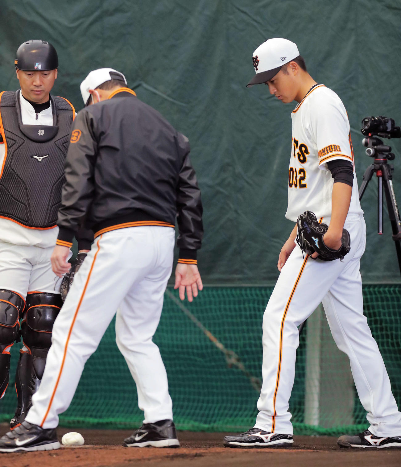 ブルペンで桑田投手チーフコーチ（左）のアドバイスを受ける巨人堀田（撮影・河田真司）