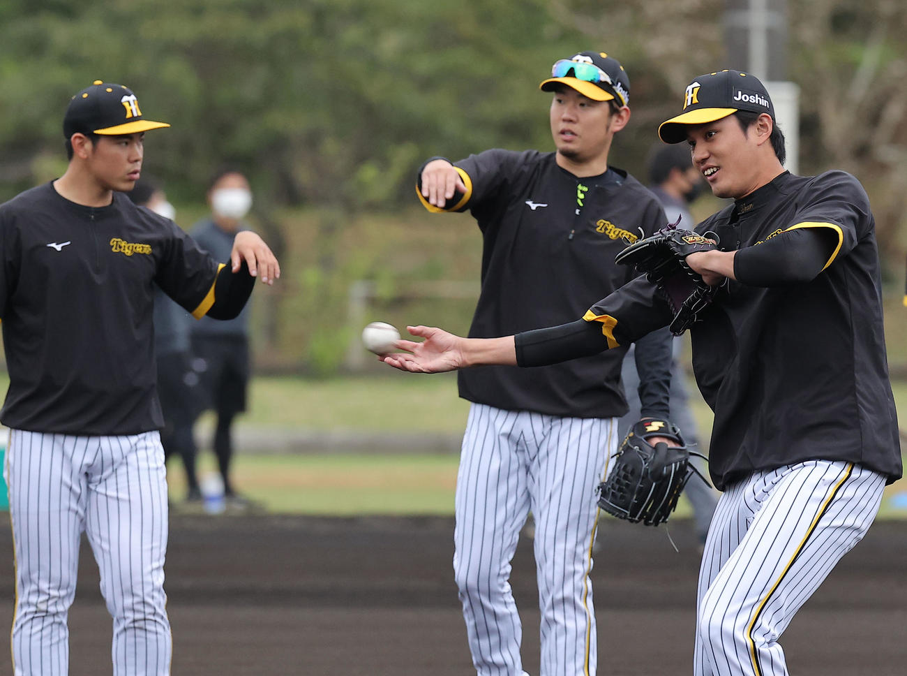 鈴木（左）にアドバイスする西勇（中央）、右は藤浪（撮影・上山淳一）