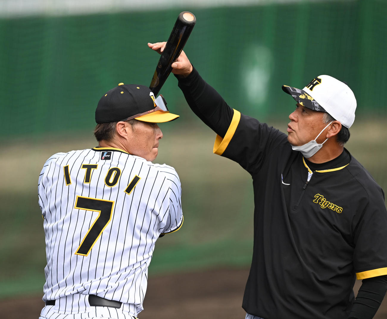 ロングティーを行う阪神糸井（左）にアドバイスする藤井コーチ（撮影・前岡正明）