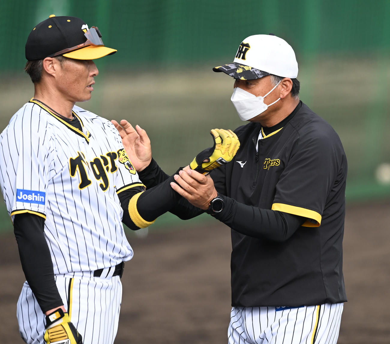 ロングティーを行う阪神糸井（左）にアドバイスする藤井コーチ（撮影・前岡正明）
