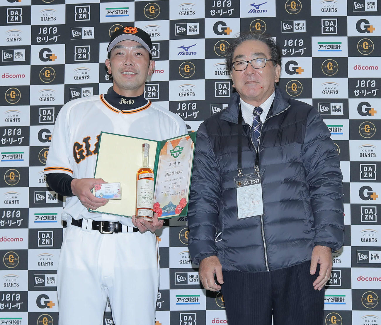 伊江村観光親善大使委嘱状交付式で伊江村長の島袋氏（右）と写真に納まる阿部作戦兼ディフェンスチーフコーチ（撮影・河田真司）