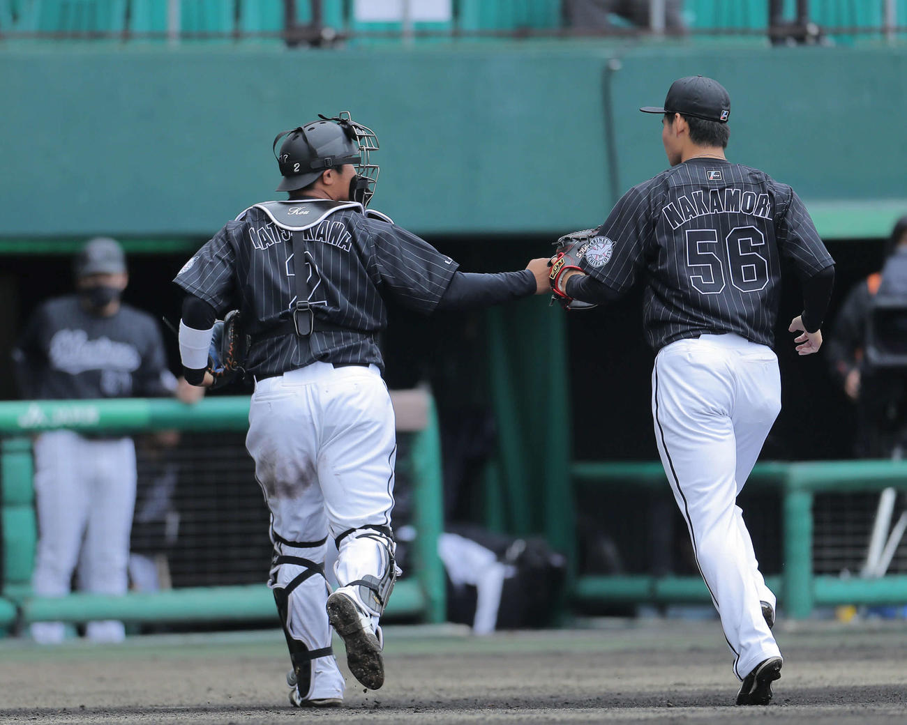 巨人対ロッテ　3回裏を抑え、ベンチに戻るロッテ松川（左）と中森（撮影・河田真司）