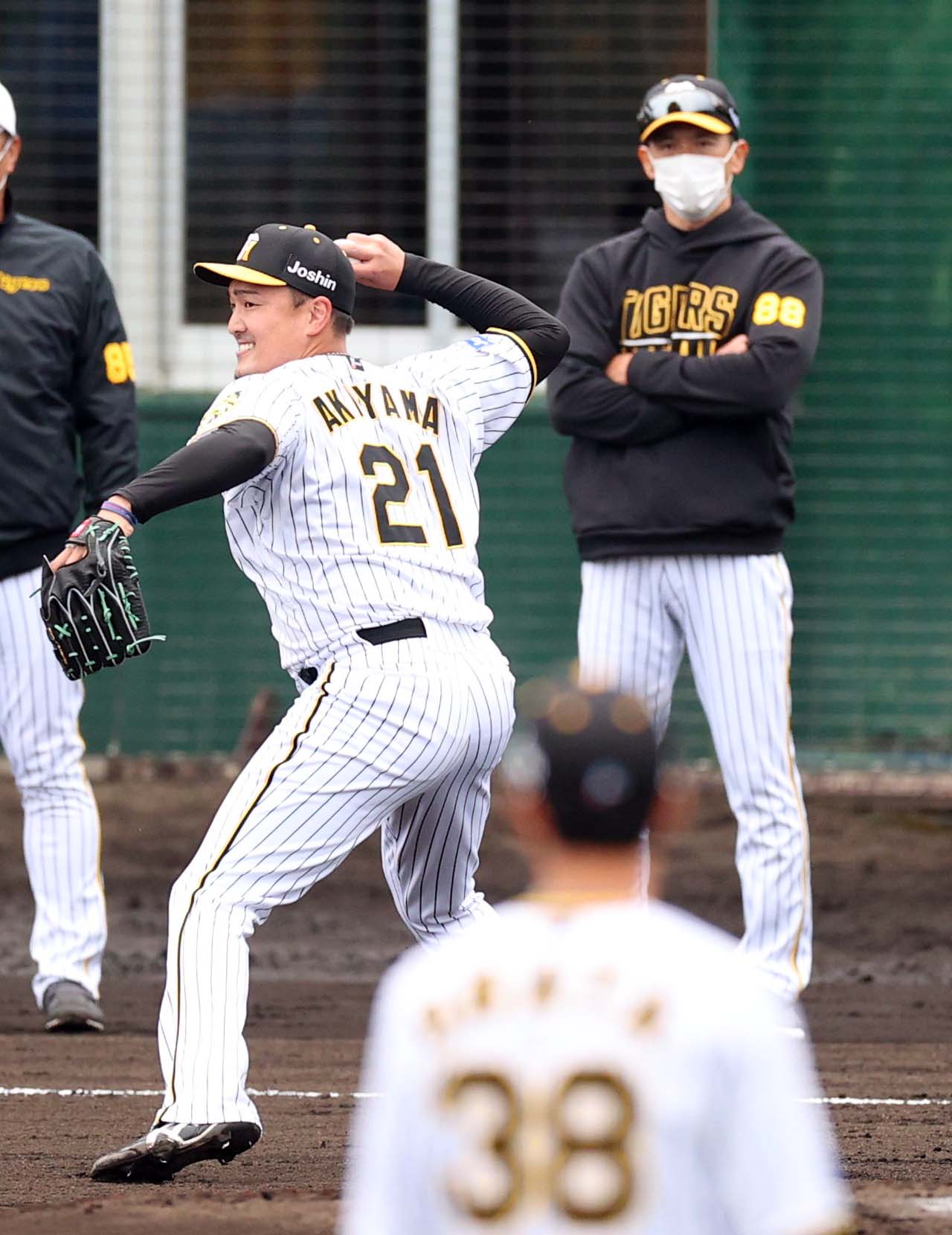 矢野監督（右）のチェックを受けながら投内連係プレーの練習に励む秋山（撮影・上田博志）