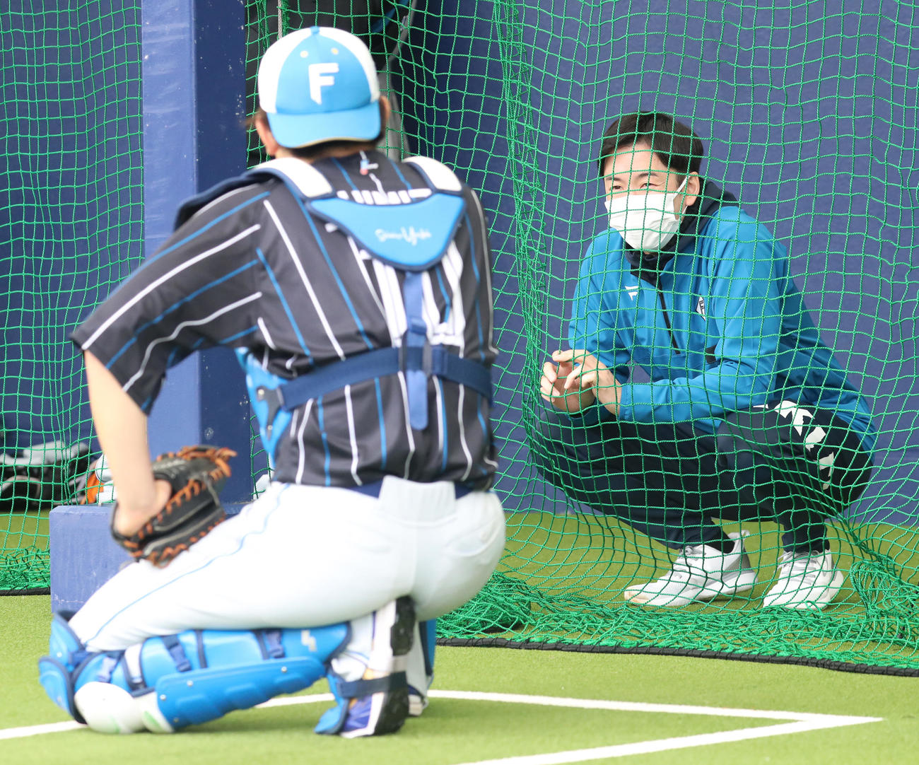 ブルペンで会話する日本ハム清水（左手前）と斎藤氏（撮影・佐藤翔太）