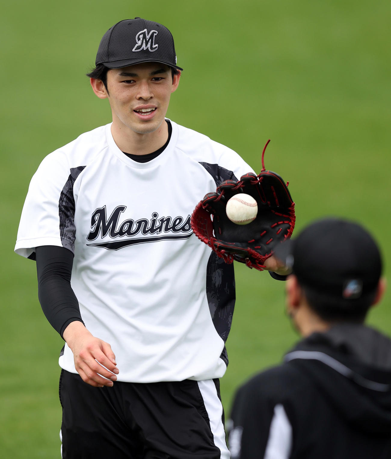 糸満2次キャンプに合流し、キャッチボールで笑顔を見せる佐々木朗（撮影・狩俣裕三）