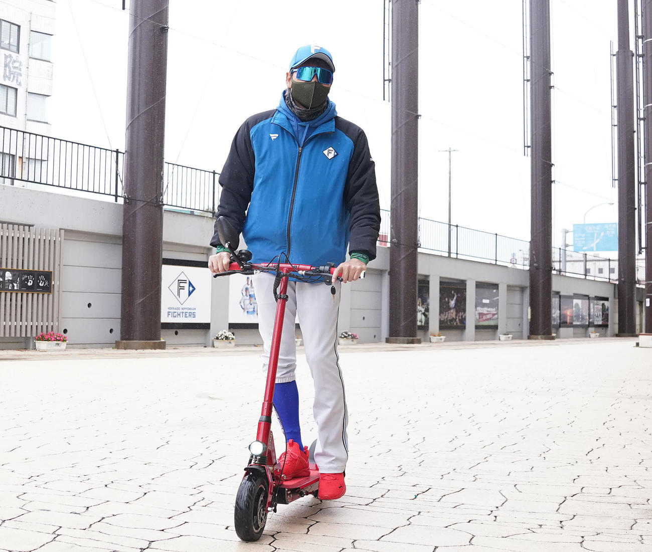 電動キックボードで室内練習場へ向かう日本ハム新庄監督（撮影・鈴木みどり）
