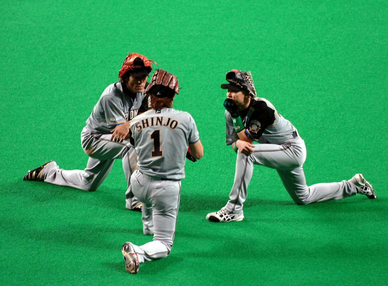 06年10月、中日との日本シリーズ第1戦で、投手交代の際に新庄（手前）と同じ格好で即席ミーティングする稲葉（左）。右は森本