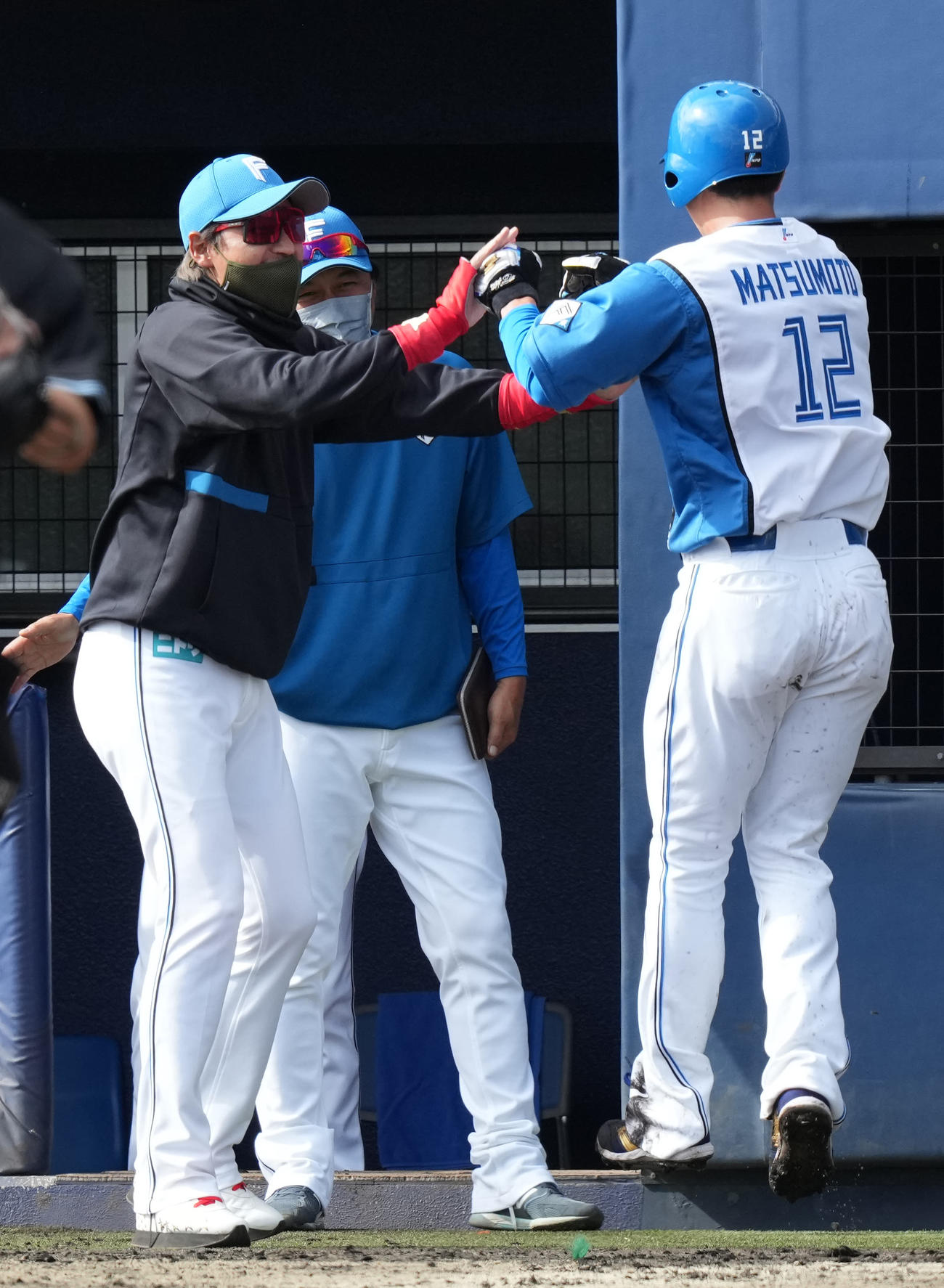 日本ハム対ロッテ　8回裏日本ハム2死二塁、佐藤の左前適時打で生還した松本剛（右）と笑顔でタッチを交わす新庄監督（撮影・鈴木みどり）