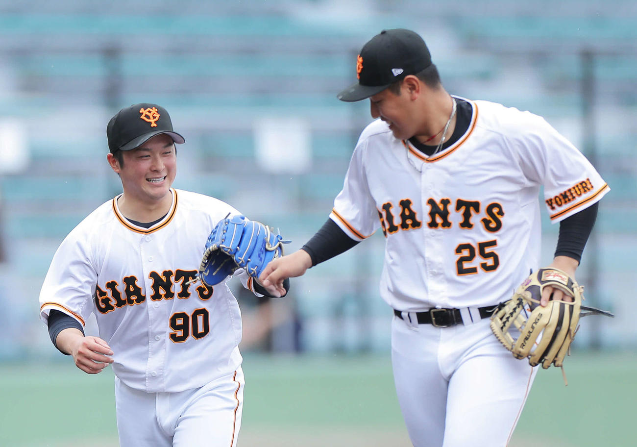 巨人対広島　1回表を抑え、グラブタッチを交わす巨人戸田（左）と岡本和（撮影・河田真司）